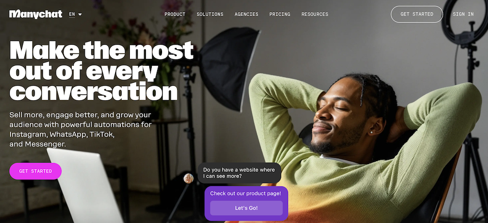 A smiling man relaxes in an office chair with his hands behind his head, facing a bright light. Text on screen promotes ManyChat AI Chatbot Platform’s audience automation for social apps, with a “Get Started” button and chatbot pop-up visible.